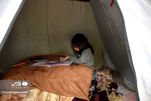 درس خواندن کودک در چادر در هوای سرد زمستانی