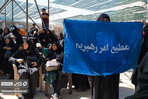 بانویی که درمراسم ارتحال امام خمینی (ره)شرکت کرده پرچمی به دست دارد که بر روی ان نوشته شده«مطیع امر رهبریم».