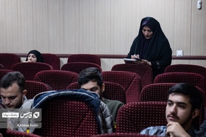 یکی از شرکت کنندگان در حال یادداشت نکات گفته شده توسط اساتید است