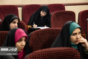 یکی از شرکت کنندگان در حال یادداشت نکات گفته شده توسط اساتید است