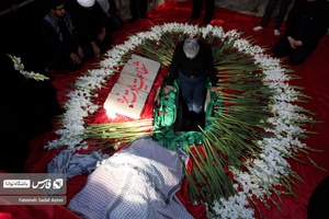 یکی از خادمین شهدا در محل دفن پیکر شهید گمنام مشغول نیایش  است .