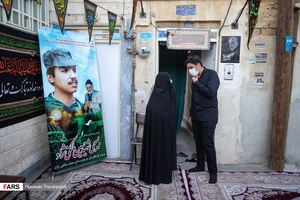  مادر شهید  بسیجی حسین مالکی‌نژاد در مراسم روضه خوانی در مقابل منزلشان با  مداحی  حاج علی مالکی نژاد
