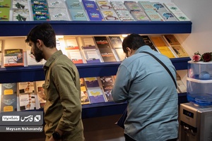 دو جوان که در حال دیدن کتاب های انتشارات فارس هستند