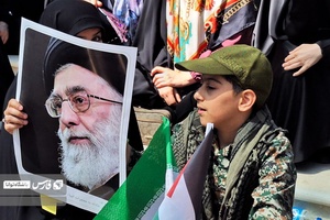 بانویی که به همراه پسر نوجوان خوددرمراسم ارتحال امام خمینی شرکت کرده، پوستررهبرانقلاب رادردست دارد