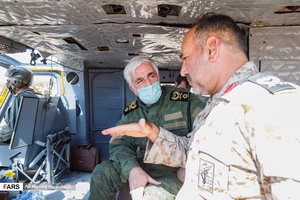 سردار پاسدار مصطفی محمدی فرمانده تیپ مکانیزه امام زمان (عج) (سمت راست تصویر) در حال ارائه گزارش به  سردار سرتیپ پاسدار ولی معدنی معاون عملیاتی نیروی زمینی سپاه پاسداران انقلاب اسلامی قبل از بازدید هوایی از منطقه است.