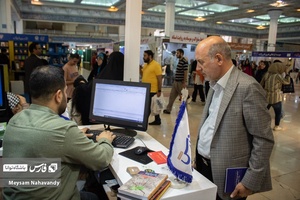 یکی از بازدیدکنندگان انتشارات فارس ، در حال خرید کتاب از این غرفه میباشد