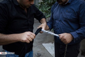 دور پیچ کردن پارچه به زنجیر برای جلوگیری از سوزش دست  در مراسم مذهبی پولکه پرانی