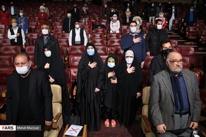 ادای احترام شرکت کنندگان در مراسم رونمایی از تندیس شهید سپهبد قاسم سلیمانی هنگام پخش سرود ملی در برج میلاد