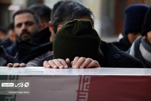 جوانی با پیکر شهید گمنام در حرم حضرت معصومه (س) وداع می‌کند.