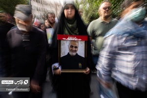 خانمی که عکس قاسم سلیمانی رادر دستان خود دارد و در مراسم  تشیع اسماعیل هنیه شرکت کرده است