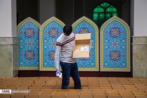 جلال عباسی یکی از نیروهای داوطلب در حال بسته بندی و آماده سازی اقلام بهداشتی برای خانواده های نیازمند / امامزاده قاضی الصابر تهران